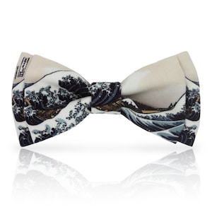 May include: A bow tie with a print of Hokusai's "The Great Wave off Kanagawa." The bow tie has a cream background with navy blue and white waves, and a small boat. A classic accessory for formal wear.
