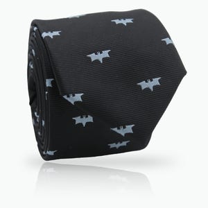 May include: Rolled black tie with a repeating light blue bat symbol pattern. The tie is made of a textured fabric and is displayed on a white background. The tie is a classic accessory.