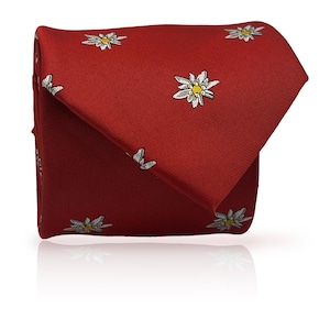 May include: A folded red tie featuring a repeating pattern of white and yellow flower designs. The tie is made of a smooth fabric and is displayed on a white surface.