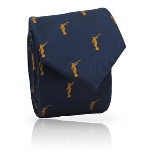 Könnte beinhalten: Marineblaue Krawatte mit einem sich wiederholenden Muster goldfarbener Figuren. Die Krawatte ist gefaltet und zeigt ihre Textur. Die detaillierten Figuren verleihen dem Design eine elegante Note. Geeignet für formelle Anlässe.