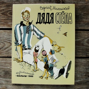 May include: A vintage children's book cover featuring a cartoon illustration of a man in a striped shirt and white pants. The title of the book is "Дядя Степа" (Uncle Stepan) and the author is "Сергей Михалков".