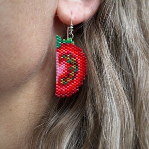 Boucles d'oreilles quartier de tomate, tissées avec des perles de rocaille Miyuki Delica, sur des crochets de boucle d'oreille en argentium 93,5 dans une boîte en papier kraft.