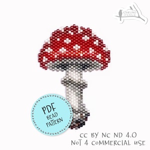 Op de afbeelding: Een kralen paddenstoelontwerp met een rode kap met witte kralen. De steel is grijs en wit. Een lichtblauwe cirkel met de tekst "PDF BEAD PATTERN" staat onderaan. De tekst "CC BY NC ND 4.0 NOT 4 COMMERCIAL USE" is ook opgenomen.