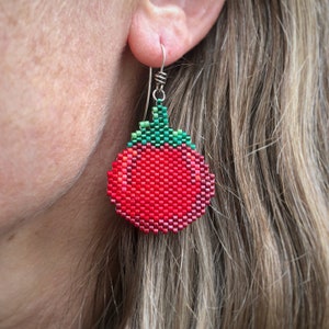 Boucles d'oreilles bouteille de sauce tomate, tissées avec des perles de rocaille Miyuki Delica, sur des crochets de boucle d'oreille français en argentium 93,5 dans une boîte en papier kraft.
