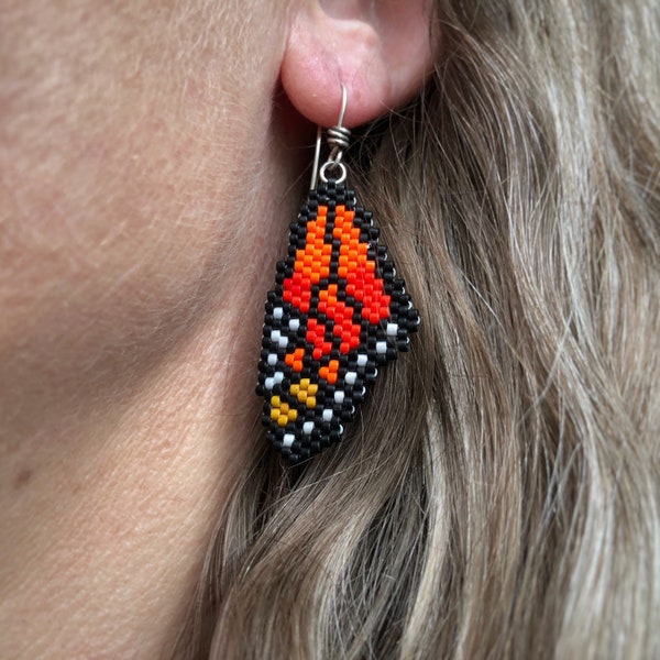 Monarch Butterfly earrings, woven with Miyuki Delica seed beads, on Argentium Silver 93.5 French earring hooks in a Kraft paper box.