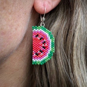 Boucles d'oreilles pastèque, tissées avec des perles de rocaille Miyuki Delica, sur des crochets de boucle d'oreille en argentium 93,5 dans une boîte en papier kraft.