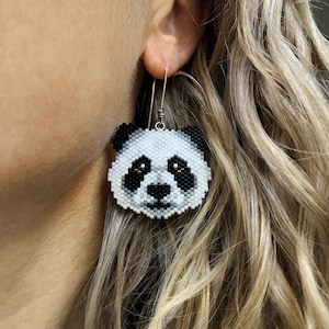 Boucles d'oreilles panda, tissées avec des perles de rocaille Miyuki Delica, sur des crochets de boucles d'oreilles en argentium 93,5 français dans une boîte en papier kraft.