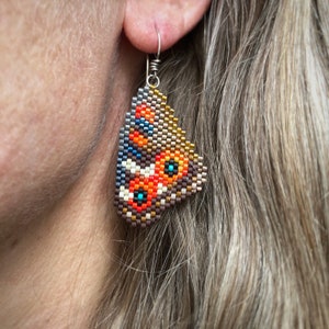 Boucles d'oreilles Meadow Argus Butterfly, tissées avec des perles de rocaille Miyuki Delica, crochets de boucle d'oreille français argentium 93,5 dans une boîte en papier kraft.