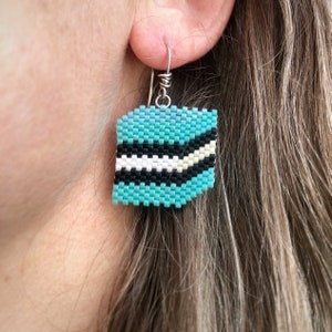 Boucles d'oreilles toutes sortes de réglisse bleue, tissées avec des rocailles Miyuki Delica, sur des crochets de boucle d'oreille français en argentium 93,5 dans une boîte en papier kraft.