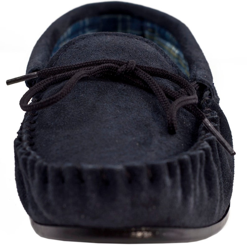 May include: A pair of navy blue suede moccasins with a black leather sole and a black lace tie.