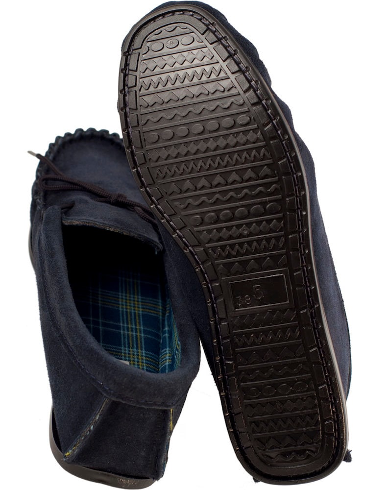 May include: A pair of dark blue suede moccasins with a plaid lining. The soles are black rubber with a textured pattern.
