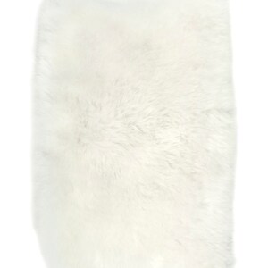 May include: A white fluffy sheepskin rug. The rug is soft and plush, perfect for adding a touch of warmth and comfort to any room.