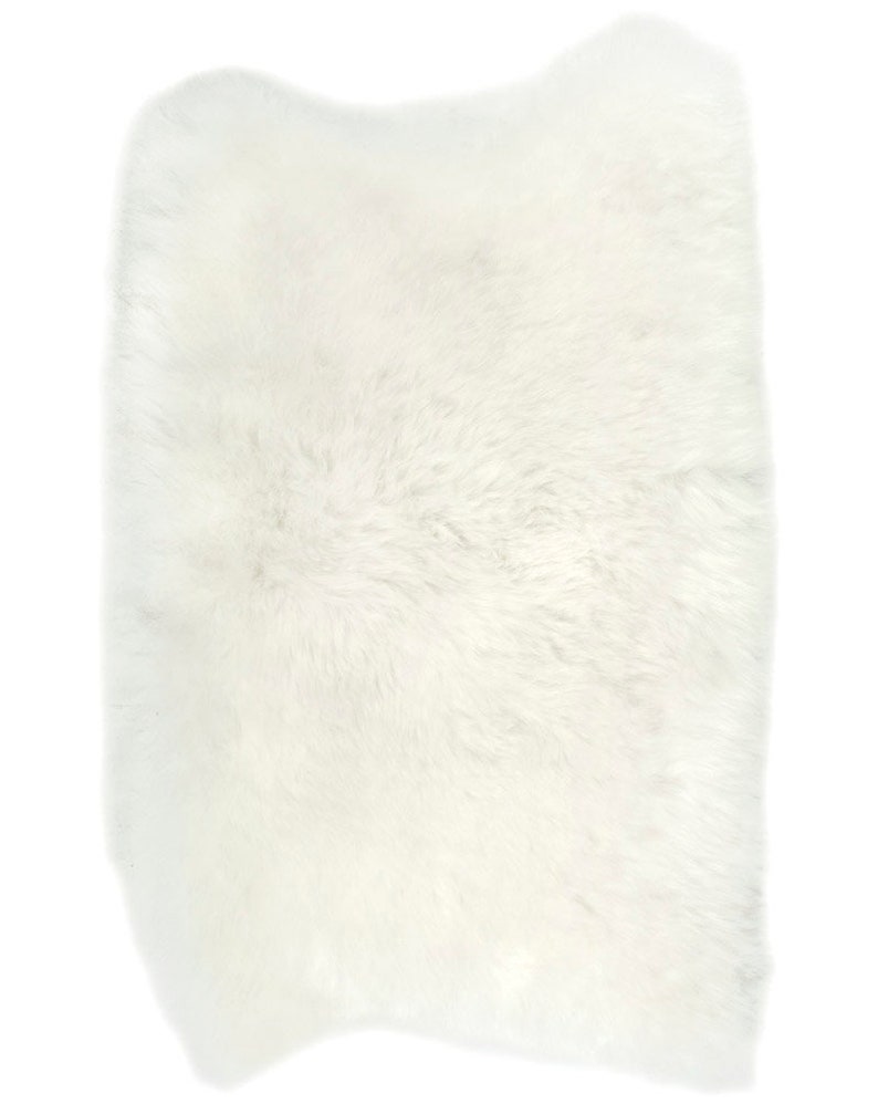 May include: A white fluffy sheepskin rug. The rug is soft and plush, perfect for adding a touch of warmth and comfort to any room.