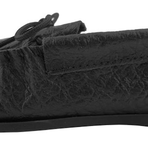 Op de afbeelding: Zwarte leren mocassinslippers met een eenvoudig ontwerp. De slippers hebben een zachte, comfortabele uitstraling en gevoel.