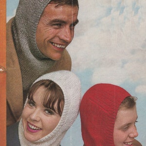 May include: Three people wearing knitted balaclavas. The balaclavas are gray, white, and red. The people are looking at the camera.