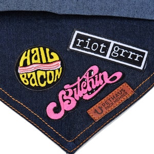 Può includere: Un toppa di denim blu con quattro toppe ricamate. Le toppe sono: "Hall Bacon", "Bitchin", "riot grrr" e "U-Pethaus Pack Member".