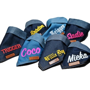 May include: A collection of six denim dog bandanas with different embroidered names, including "Trigger", "Coco", "Brxton", "Willie Dog", "Sadie", and "Miekia".
