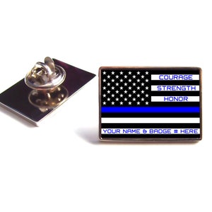 May include: A silver lapel pin with a thin blue line American flag design. The flag has the words "Courage", "Strength", and "Honor" printed on it. The bottom of the pin says "Your Name & Badge # Here".