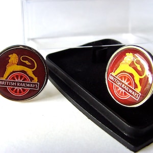 May include: A pair of cufflinks featuring the British Railways logo. The logo is a red and gold lion with a wheel and the words "British Railways".