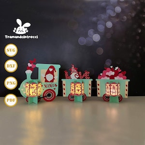 May include: A Valentine's Day-themed train set with three cars. The train is light teal with red wheels and accents. Each car features a different design, including gnomes, hearts, and the word "love." The train cars have illuminated lanterns.