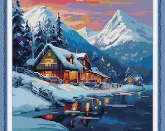 May include: A cross-stitch of a winter landscape featuring snow-covered cabins nestled near a lake, with snow-capped mountains in the background. The sky transitions from pink to blue, reflecting in the water. The cabins have lit windows.