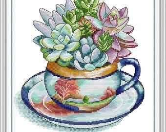 May include: Cross-stitch design of a teacup and saucer filled with succulents. The teacup features a landscape scene with a tree and a blue rim. The succulents are various shades of green, blue, and purple.