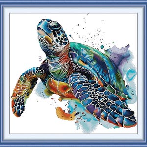 May include: A framed watercolor-style cross-stitch of a sea turtle. The turtle features a vibrant palette of blues, greens, oranges, and purples. The artwork is set against a white background, with a blue frame.