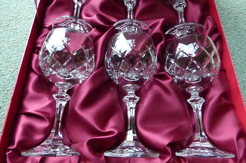 K&ouml;nnte beinhalten: Set aus vier Kristallweingl&auml;sern mit geschliffenem Glasdesign. Die Gl&auml;ser werden in einer roten Samtbox pr&auml;sentiert.