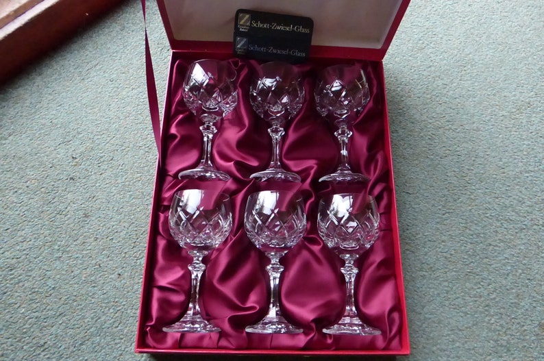K&ouml;nnte beinhalten: Satz von sechs klaren Kristallweingl&auml;sern in einer mit rotem Samt ausgekleideten Schachtel. Die Schachtel tr&auml;gt ein Etikett mit der Aufschrift "Schott Zwiesel Glass".