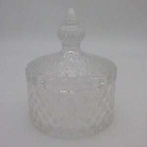 May include: A clear glass jar with a lid. The jar has a diamond pattern and the lid has a pointed top.