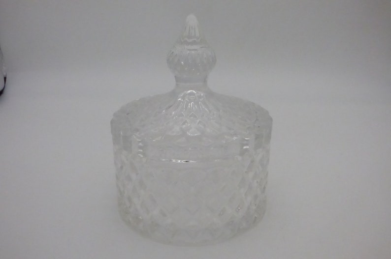 May include: A clear glass jar with a lid. The jar has a diamond pattern and the lid has a pointed top.