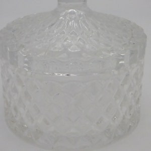 May include: A clear glass jar with a lid, both featuring a diamond pattern.