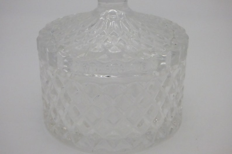 May include: A clear glass jar with a lid, both featuring a diamond pattern.