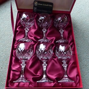 K&ouml;nnte beinhalten: Satz von sechs klaren Weingl&auml;sern aus geschnittenem Kristall in einer mit rotem Samt ausgekleideten Schachtel. Die Schachtel tr&auml;gt ein Etikett mit der Aufschrift "Schon Zwarend Glas".