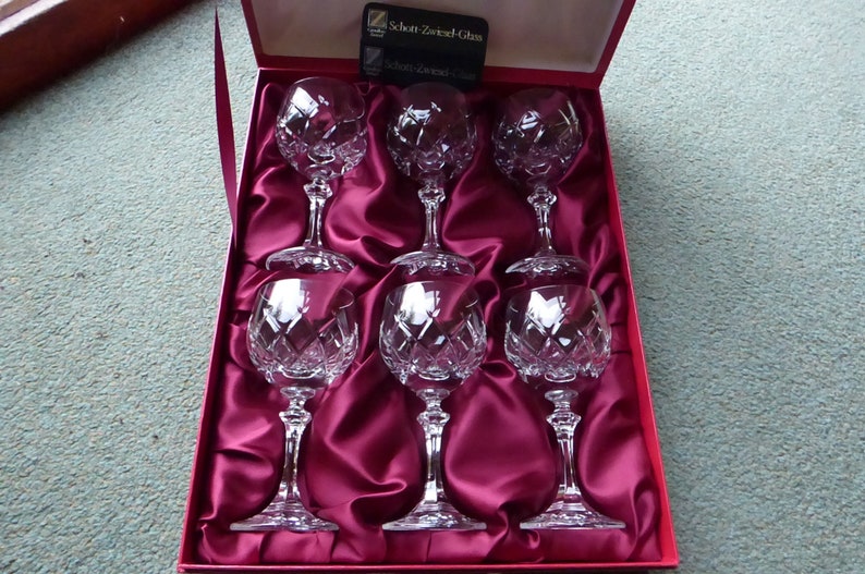 K&ouml;nnte beinhalten: Satz von sechs klaren Weingl&auml;sern aus geschnittenem Kristall in einer mit rotem Samt ausgekleideten Schachtel. Die Schachtel tr&auml;gt ein Etikett mit der Aufschrift "Schon Zwarend Glas".