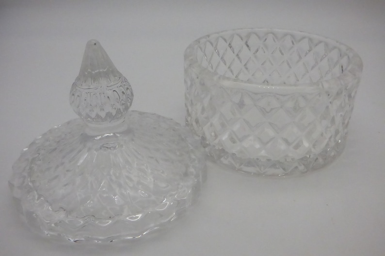 May include: A clear glass jar with a lid. The jar has a diamond pattern and the lid has a decorative knob.