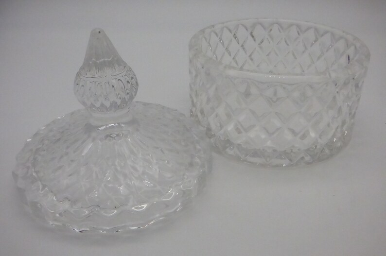 May include: A clear glass jar with a lid. The jar has a diamond pattern and the lid has a knob on top.