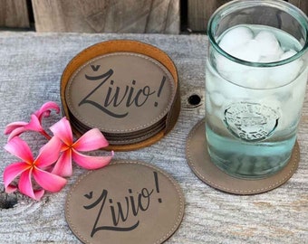 May include: Set of six brown leather coasters with a stitched edge. Each coaster features the word "Zivio!" in a stylized font. The coasters are stacked in a brown leather holder.