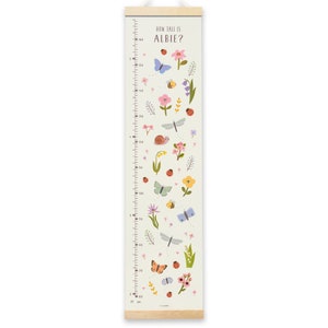 May include: A white growth chart with a green background and colorful illustrations of flowers, butterflies, ladybugs, and a snail. The chart is labeled "How Tall is Albie?" and has measurements in inches and centimeters.