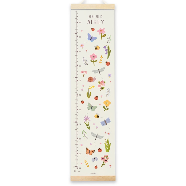 May include: A white growth chart with a green background and colorful illustrations of flowers, butterflies, ladybugs, and a snail. The chart is labeled "How Tall is Albie?" and has measurements in inches and centimeters.