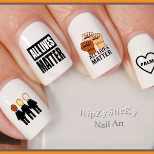 May include: White nail art stickers with black text and graphics. Designs include the text "ALL LIVES MATTER", a fist with three skin tones, a heart with "#ALM", and three stick figures with different skin tones. The brand name "HipZySticky Nail Art" is also visible.
