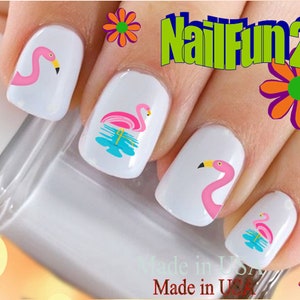 May include: Pink flamingo nail decals with a blue water design. The decals are applied to white painted fingernails. The image includes the text "NailFun2U".