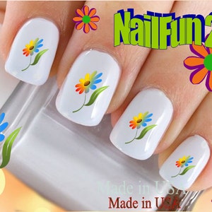 May include: Close-up of fingernails with colorful daisy nail art decals. The decals feature a yellow center, orange petals, blue petals, and green leaves. The text "NailFun2U" is visible in the background.