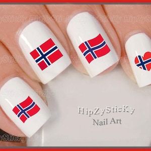 May include: Close-up of fingernails with nail art featuring the Norwegian flag in various designs, including a heart shape. The nail art is white with red, blue, and white accents. The text "HipZySticky Nail Art" is visible in the image.