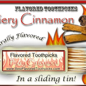 May include: A red and white label with the text "Flavored Toothpicks Fiery Cinnamon" and the website address "www.BestFlavoredToothpicks.com". The label is on a white background with a red border. There are cinnamon sticks and flames on the label. A tin of toothpicks is visible in the background.