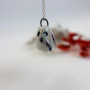 Handgjort litet skimrande lavendelfärgat spökhänge i porslin och keramik med kedja i sterlingsilver