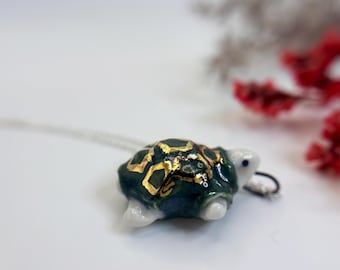 手作りの磁器製ウミガメのペンダント。ゴールドのアクセント付き。スターリングシルバーのチェーン付き。