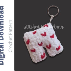 May include: A white plush crochet keychain shaped like the letter N, featuring small red embroidered hearts throughout the surface. The keychain includes a silver metal ring. Text on the image reads Digital Download Crochet Pattern Stitched by JoAnna.