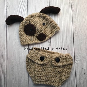 May include: A crocheted dog hat and diaper set in brown and beige with black buttons. The hat has brown ears and black eyes. The diaper has two black buttons on the front. The set is handcrafted by witches.