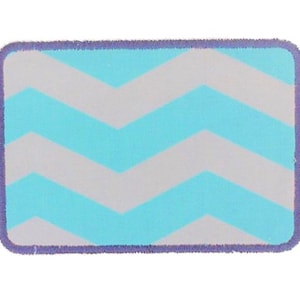 May include: A light blue and gray chevron patterned iron-on patch with a purple stitched border.